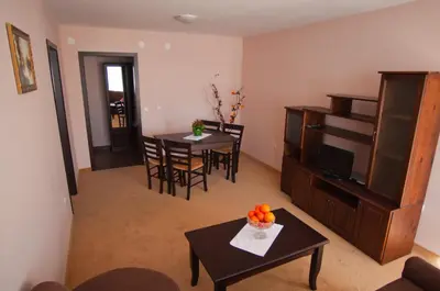 a living room with two tables and a television at Family hotel Iskar in Govedartsi