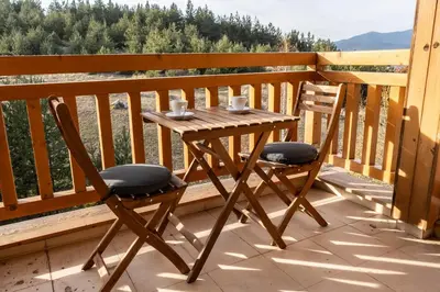 a wooden table and two chairs on a balcony at St. John Hill Apartment, Bansko in Bansko