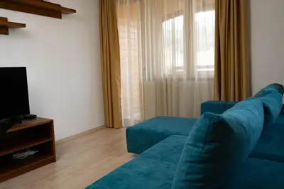 a living room with a blue couch and a television at St. John Hill Apartment, Bansko in Bansko