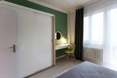 a bedroom with a bed and a desk with a mirror at The Cozy Apartment, Sofia in Sofia