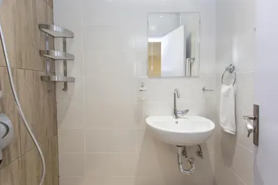 a white bathroom with a sink and a mirror at The Cozy Apartment, Sofia in Sofia