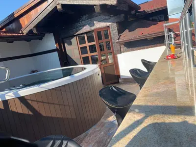 a hot tub on the side of a house at Family hotel Makedonska Kruchma in Dobrinishte