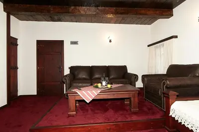 a living room with a couch and a coffee table at Family hotel Makedonska Kruchma in Dobrinishte