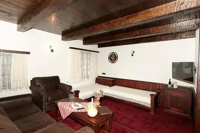 a living room with a couch and a table at Family hotel Makedonska Kruchma in Dobrinishte