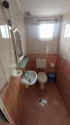 a small bathroom with a toilet and a sink at Guesthouse Pumpalovi in Dobrinishte
