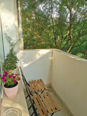 a wooden chair sitting on a balcony with a window at Fresh Apartment in Sofia