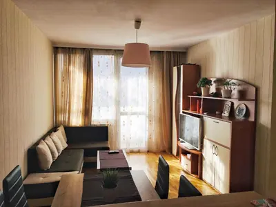 a living room with a couch and a table and a tv at Fresh Apartment in Sofia