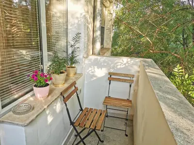 a small porch with a chair and a window at Fresh Apartment in Sofia