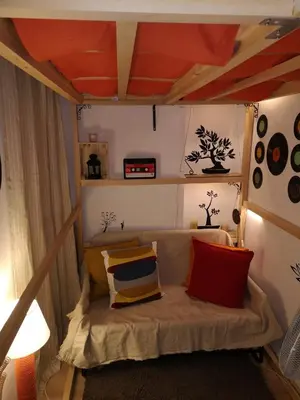 a bed in a room with an orange ceiling at Pijama Hostel in Plovdiv