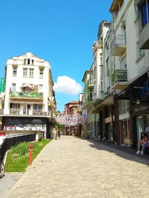 a cobblestone street in a city with tall buildings at Pijama Hostel in Plovdiv