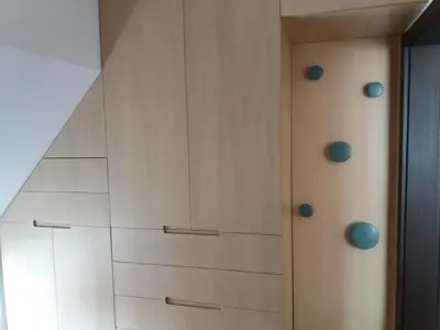 a closet with white cabinets and blue knobs at Bright apartment at a great location in Sofia