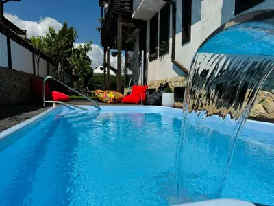 a blue swimming pool with a water fountain at Guest house Elit in Dobrinishte