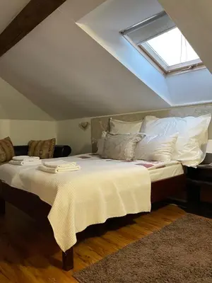 a bedroom with a bed with white sheets and a window at Guest house Elit in Dobrinishte