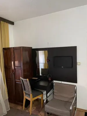 a room with a desk and two chairs and a television at Guest house Elit in Dobrinishte