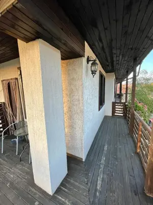 a porch of a house with a wooden deck at Guest house Elit in Dobrinishte