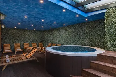 a room with a large jacuzzi in the middle of a room at Cornelia Deluxe Residence in Bansko