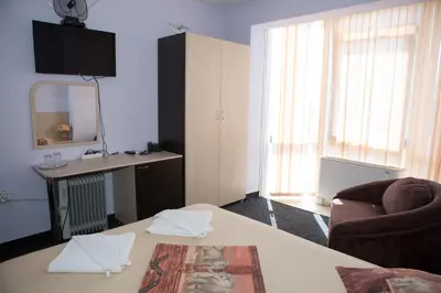 a room with a bed and a chair and a mirror at Hotel Deva in Sandanski