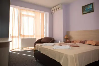 a bedroom with a bed and a large window at Hotel Deva in Sandanski