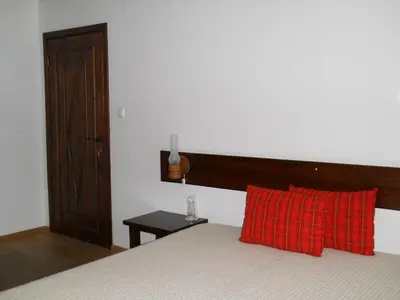 a bedroom with a bed with a red plaid pillow at Complex Kosovo Houses in Kosovo