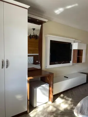 a room with a tv and a desk with a desk at Villa SUNRISE in Dospat