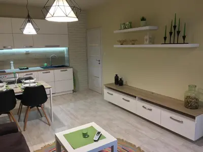 a living room with a table and a kitchen at Evergreen Sofia Apartment in Sofia