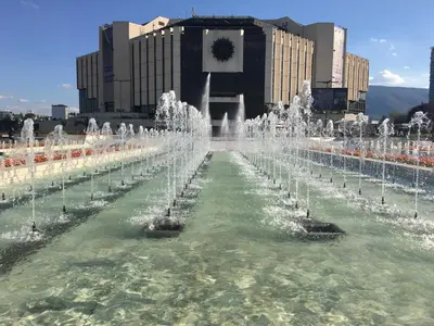 a fountain in the middle of a city with buildings at Evergreen Sofia Apartment in Sofia