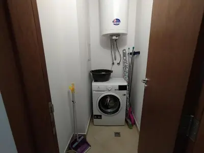 a small room with a washing machine and a pot on top at New Inn in Bansko