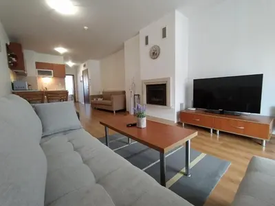 a living room with a couch and a tv at New Inn in Bansko