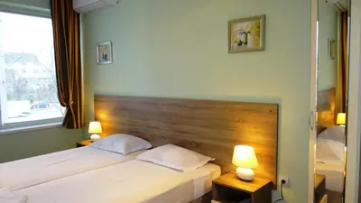 a bedroom with two beds and two lamps on tables at Guest Rooms Kom in Sofia