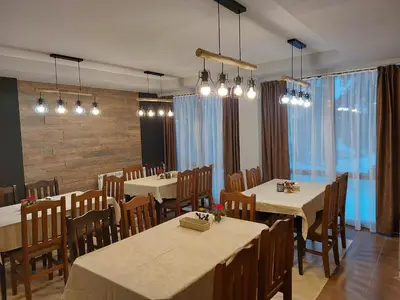 a dining room with tables and chairs and lights at Aparthotel Pine Hills Pamporovo in Pamporovo