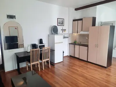 a small kitchen with a table and a refrigerator at Studio Cathlyn in Sofia