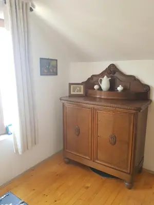 a wooden cabinet in a room with a window at The Old House guest rooms and apartament in Plovdiv