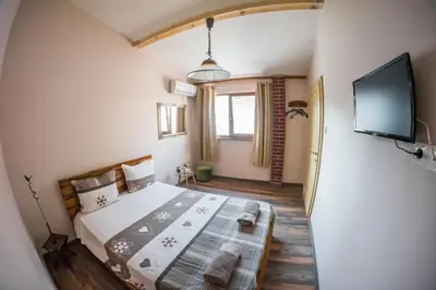 a bedroom with a bed and a flat screen tv at The Old House guest rooms and apartament in Plovdiv