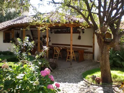 a house with a table and chairs in a garden at Tsutsovi House in Kalofer
