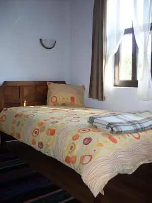 a bedroom with a bed with a colorful comforter at Tsutsovi House in Kalofer