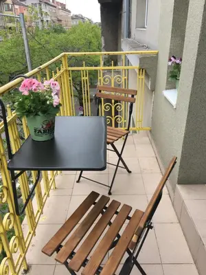 a table and chairs on a balcony with flowers at Cozy Apartment in the very centre of Sofia in Sofia