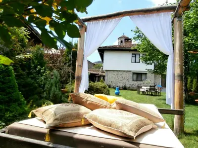 a bed with pillows on it in a yard at The Gates Apartments in Koprivshtitsa