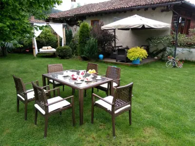 a table and chairs in a yard with a table and an umbrella at The Gates Apartments in Koprivshtitsa