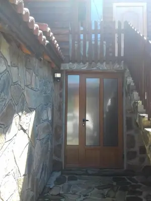a front door of a house with a stone wall at Къща Момина сълза in Sapareva Banya