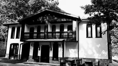 a black and white photo of a house with a balcony at Complex Magic of the Rhodopes in Bachkovo