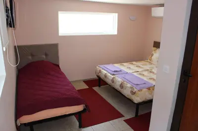 a small room with two beds and a window at Apartment Raya in Sapareva Banya