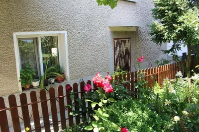a fence with flowers in front of a house at Apartment Raya in Sapareva Banya