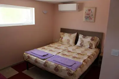 a bedroom with a bed with purple sheets and a window at Apartment Raya in Sapareva Banya