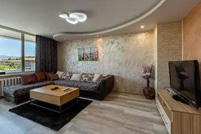 a living room with a couch and a tv at Apartments Rosina in Plovdiv