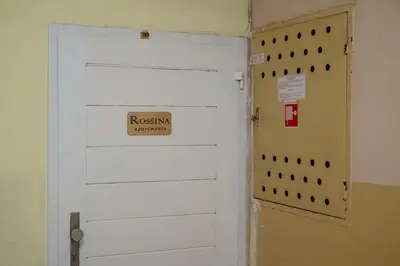 a white door with a sign on it next to a wall at Apartments Rosina in Plovdiv