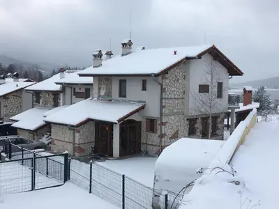 a house with snow on the roof at Къщи за гости Илиеви , Цигов Чарк in Batak