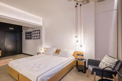 a bedroom with a large bed and a chair at R34 Boutique Hotel in Sofia
