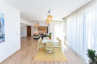 a dining room and living room with a table and chairs at Vitosha Downtown Apartments in Sofia