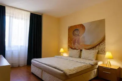 a bedroom with a bed with a large painting on the wall at Vitosha Downtown Apartments in Sofia
