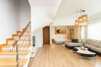 a living room with a couch and a staircase at Vitosha Downtown Apartments in Sofia